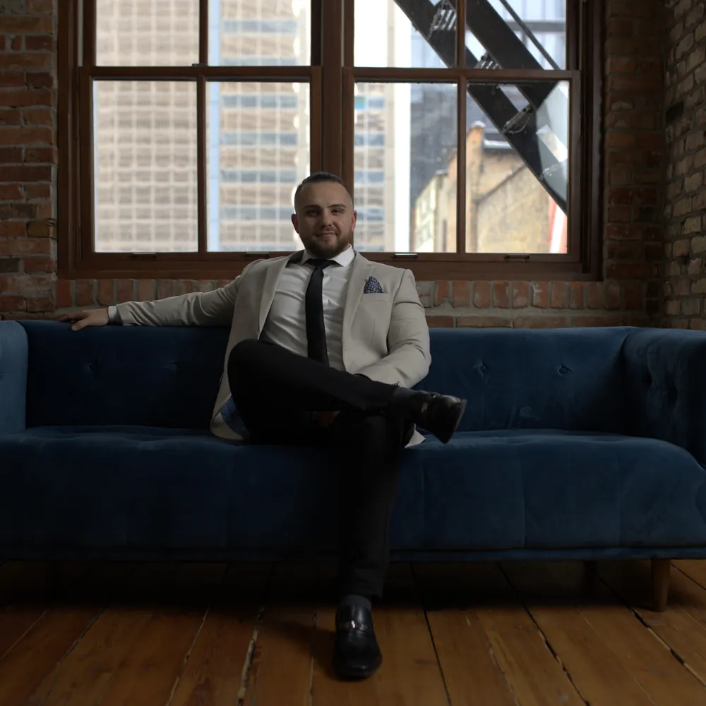 Roni Etin seated in a brick loft in Calgary